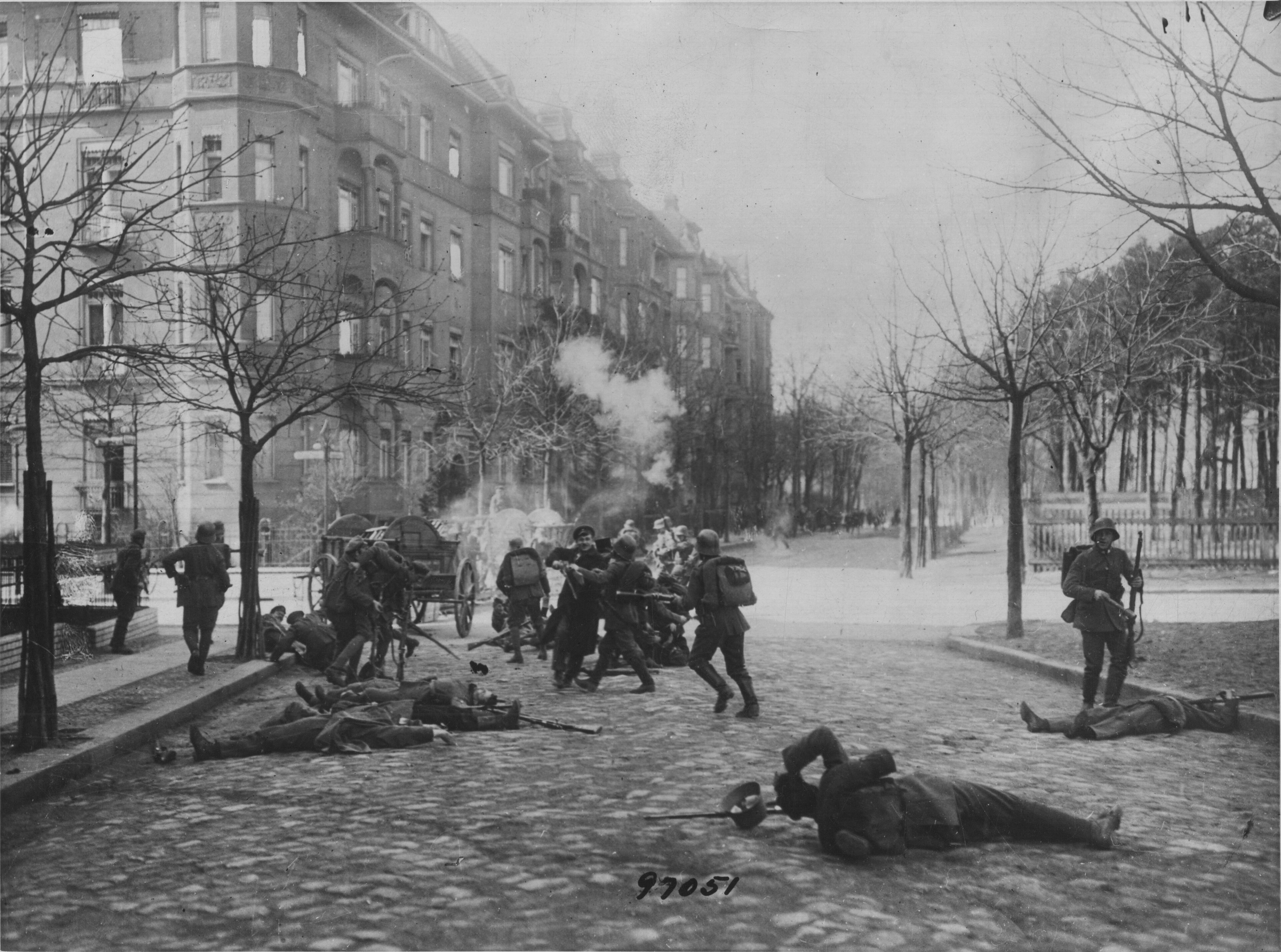 Soldiers advance among bodies in Berlin. Following the monarchy’s collapse, fighting opposed plans for a parliamentary republic and socialist revolution organised through workers’ and soldiers’ councils.